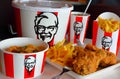 Crispy fried chicken & cup of drink served in retail background of KFC restaurant.